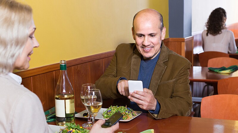 Man and woman distracted by cell phones at a restaurant