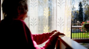 Disabled senior woman in wheelchair at home in living room