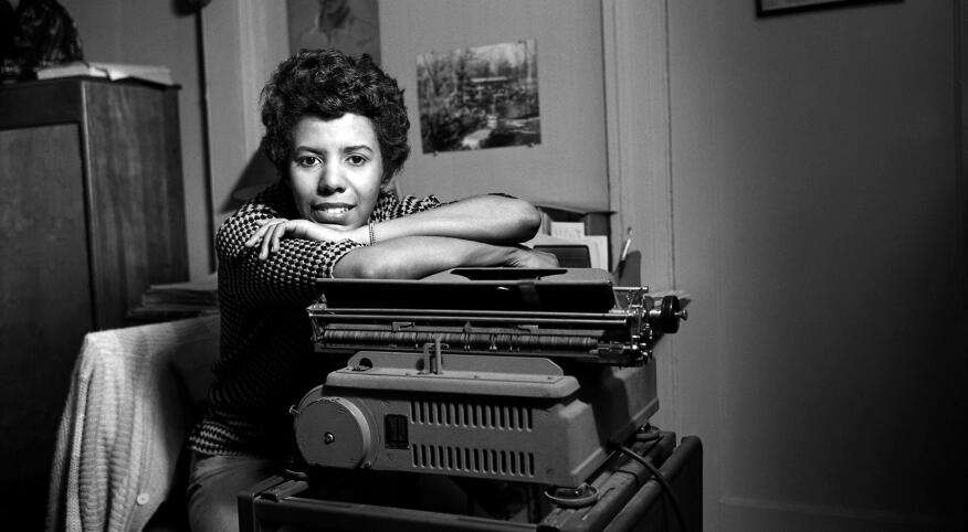 Black and white photo of Lorraine Hansberry leaning on a typewriter.