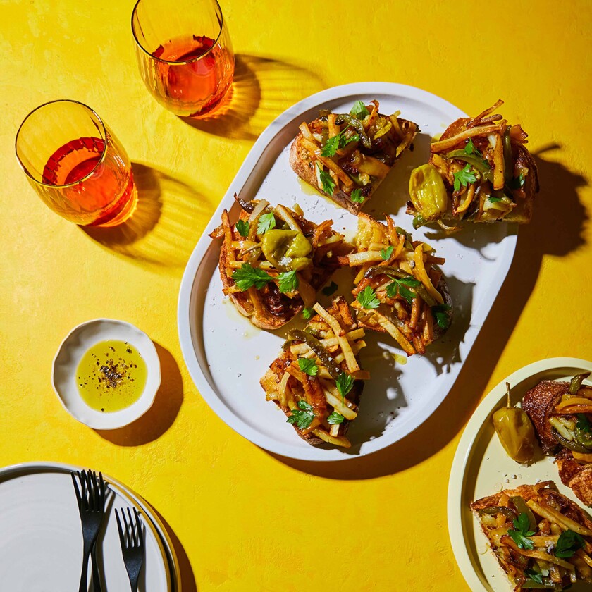 Potatoes and peppers on bread with glasses of wine