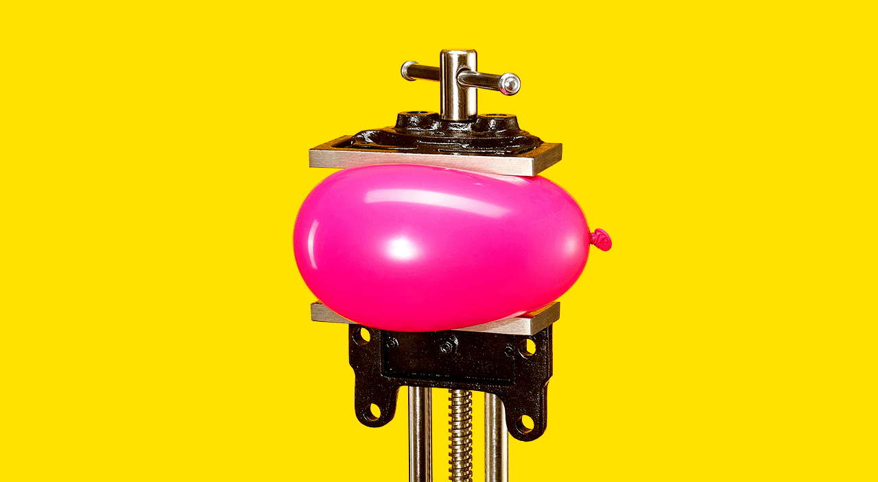 Pink balloon slowly being pressured by a closing vise