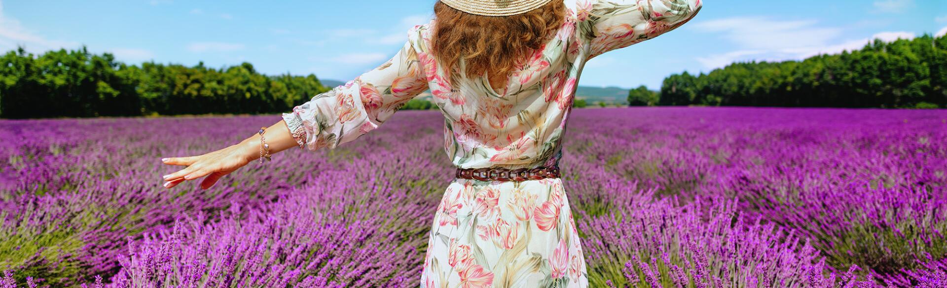 woman in sundress walking through flower field