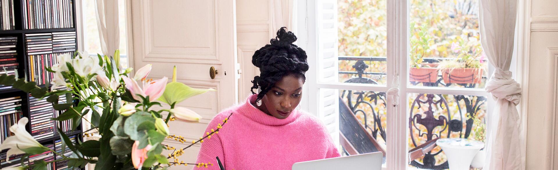 image_of_black_woman_sitting_at_table_working_on_laptop_GettyImages-1063295912_1540.jpg