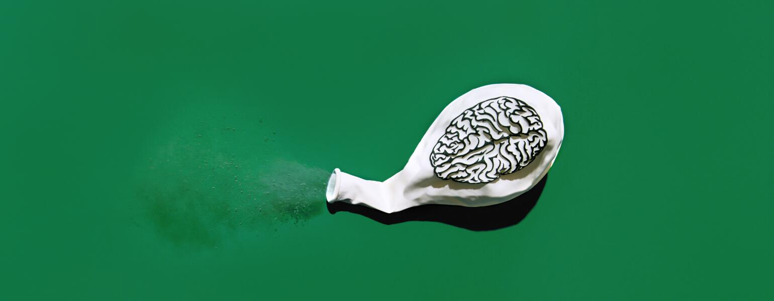 Deflated white balloon blowing out dust with a print of a brain on the balloon.