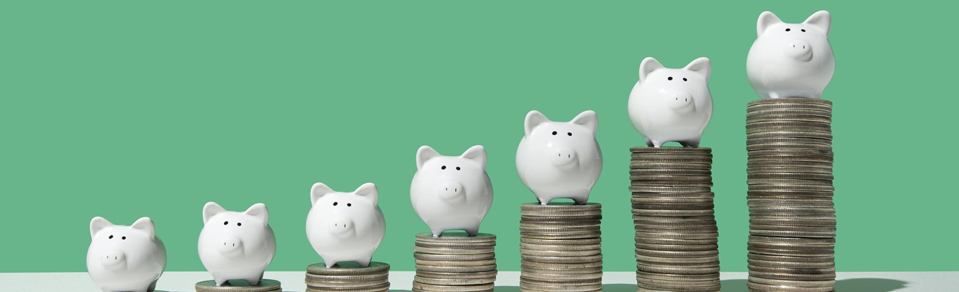 Little piggy banks on ascending stacks of coins