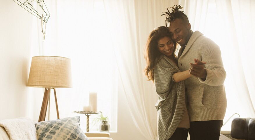 Black, biracial couple, slow dancing in living room