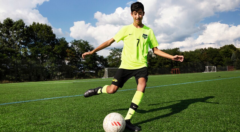 Teenager playing soccer.