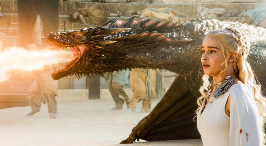 game of thrones character Daenerys Targaryen standing next to a fire breathing dragon