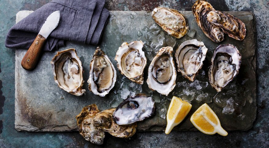 Open oysters dines de claire on stone plate with lemon