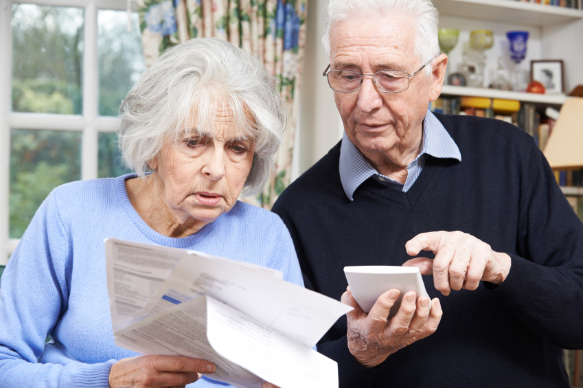 Senior Couple At Home With Bills Worried About Home Finances